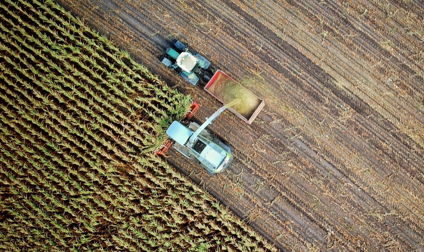 Aerial view of a harvester loading a trailer in a Herefordshire field