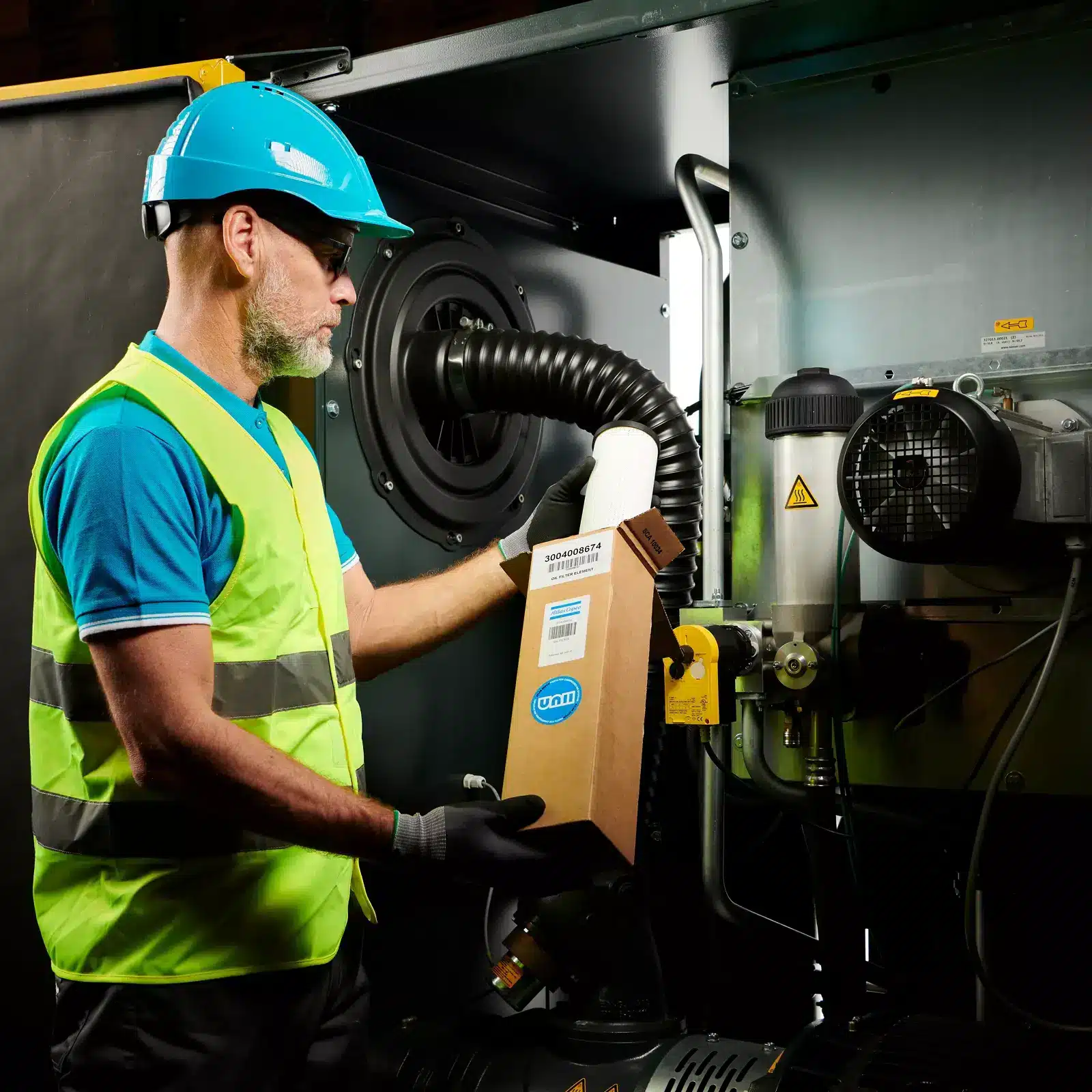 Engineer replacing a filter on an air compressor