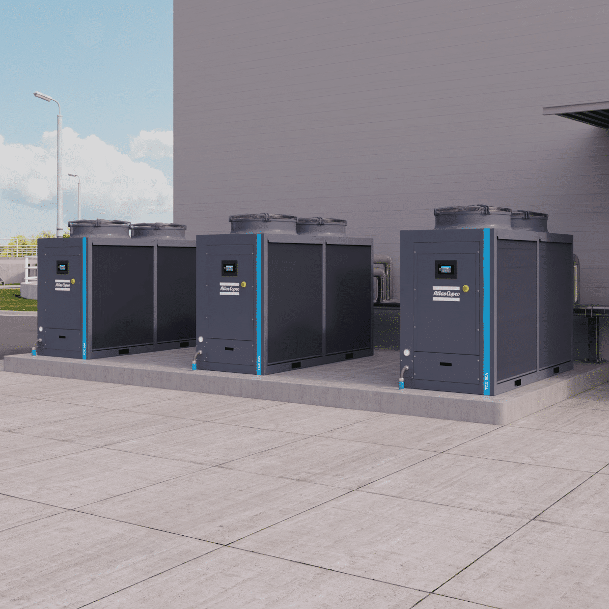 Atlas Copco air-cooled chillers on a concrete plinth outside a building
