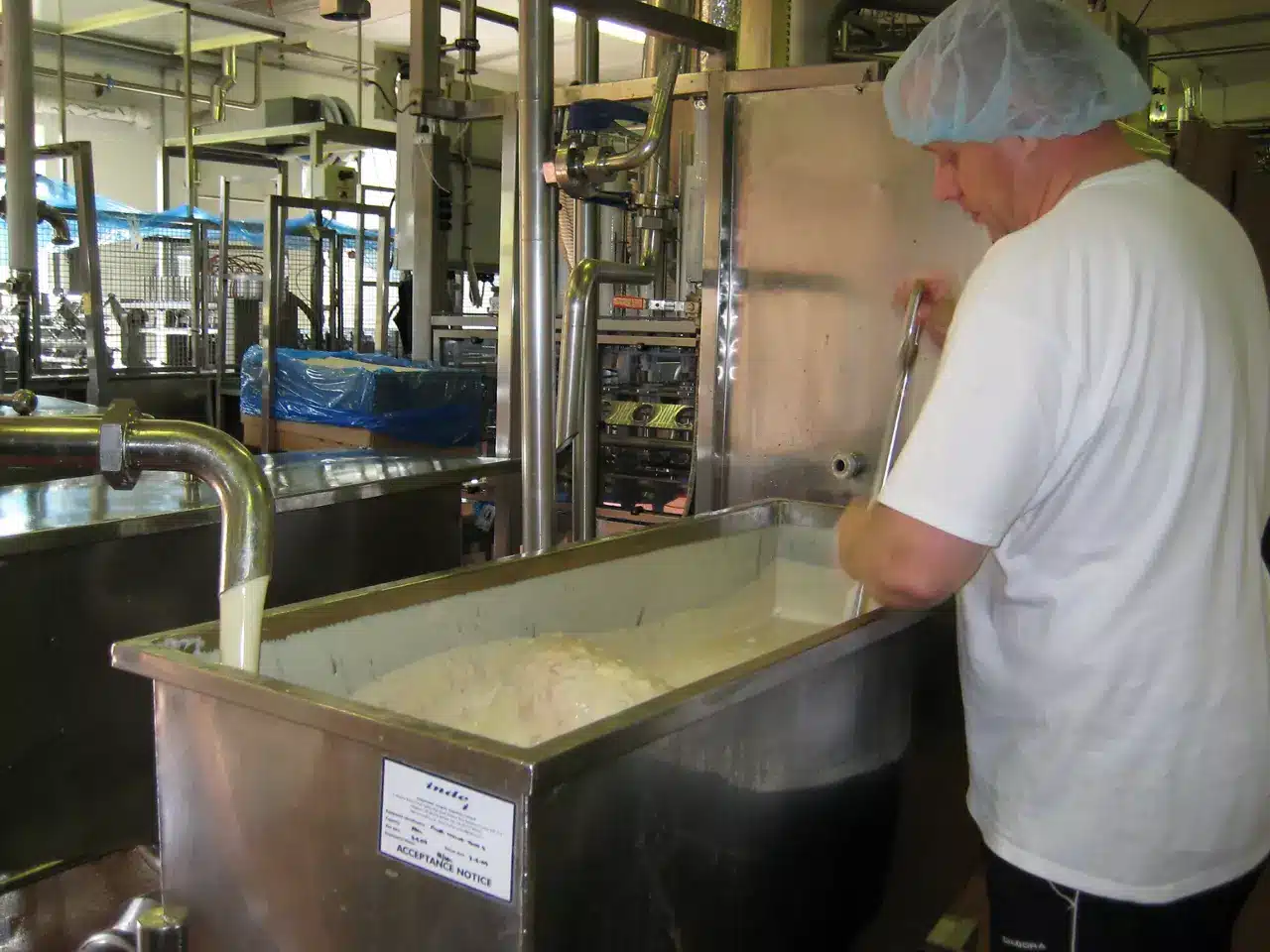 Operator at a stainless steel vat in a food processing hall