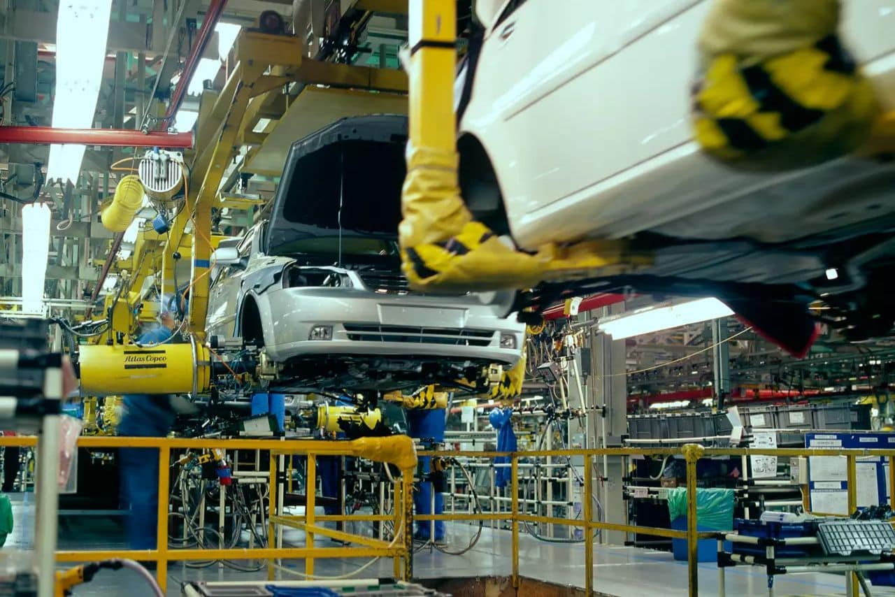 Car assembly line with Atlas Copco tool support arms